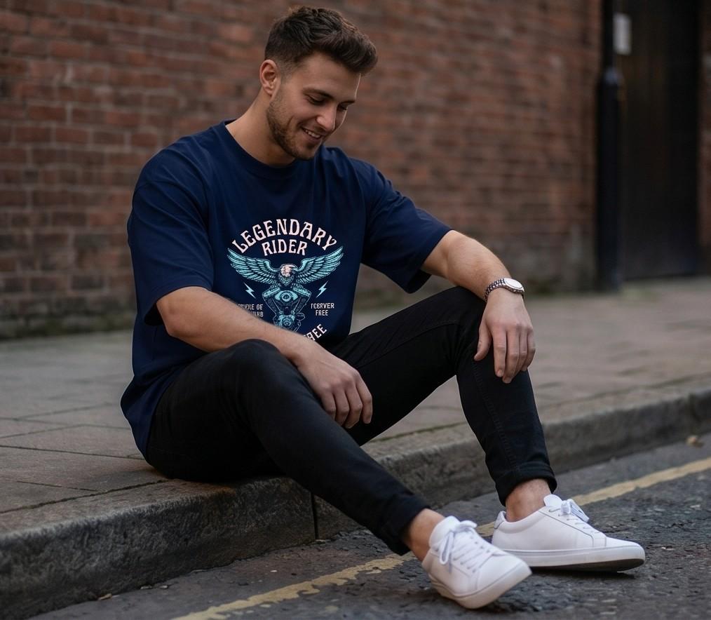 Man in navy blue graphic tee, black jeans, white sneakers