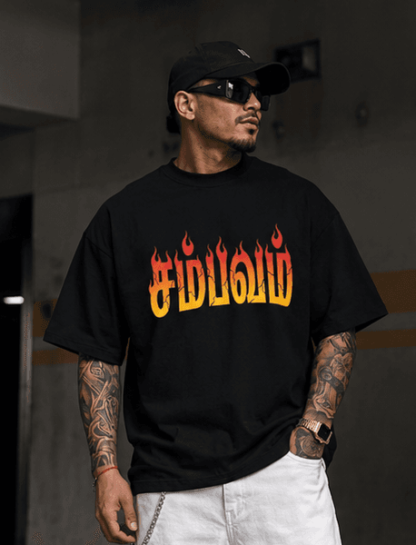 Man in black graphic tee, white pants, and cap