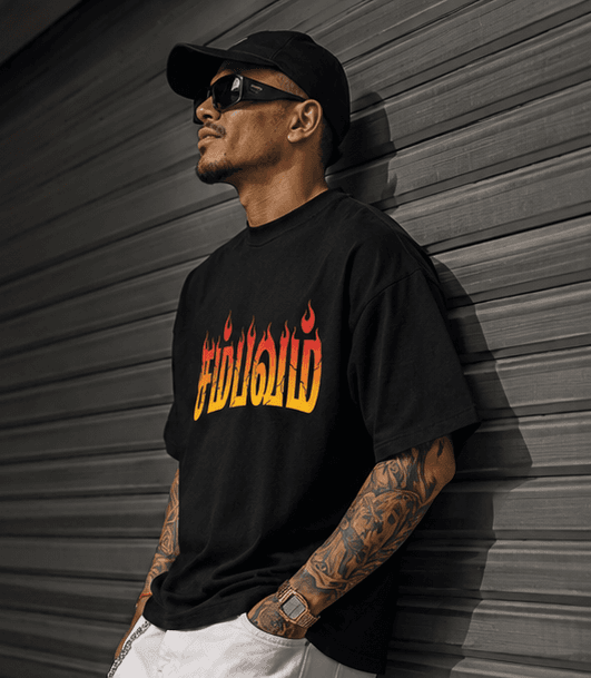 Man in black t-shirt with flame text, white pants